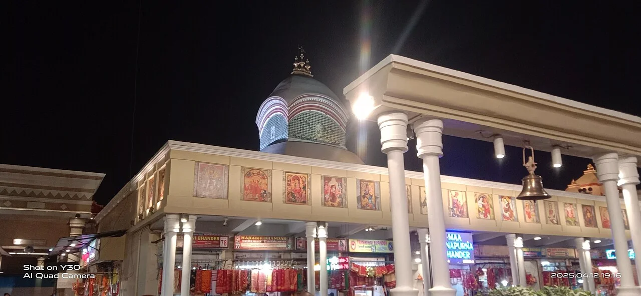 The illuminated entrance and domed roof of Kalighat Kali Temple in Kolkata at night