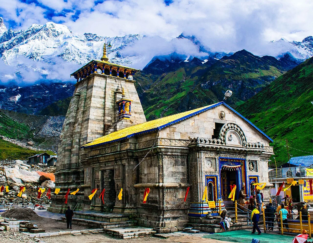Kedarnath Temple with Himalayan peaks and clouds behind its stone walls
