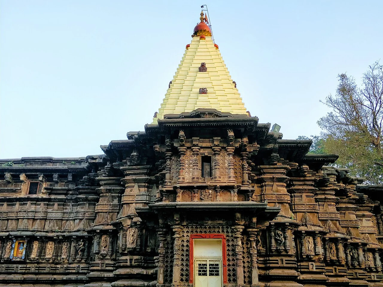 The stone facade and golden spire of Mahalakshmi Temple in Kolhapur