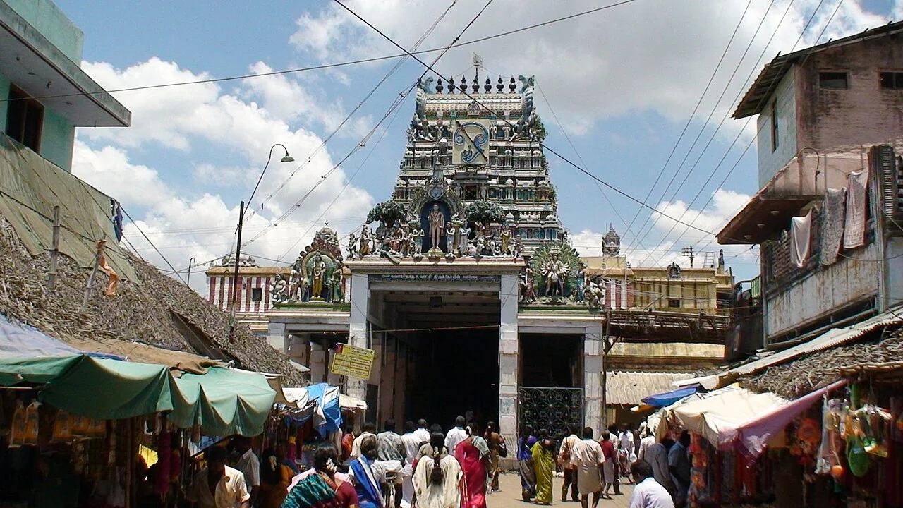 Devotees outside the colourful entrance tower of Swamimalai Murugan Temple
